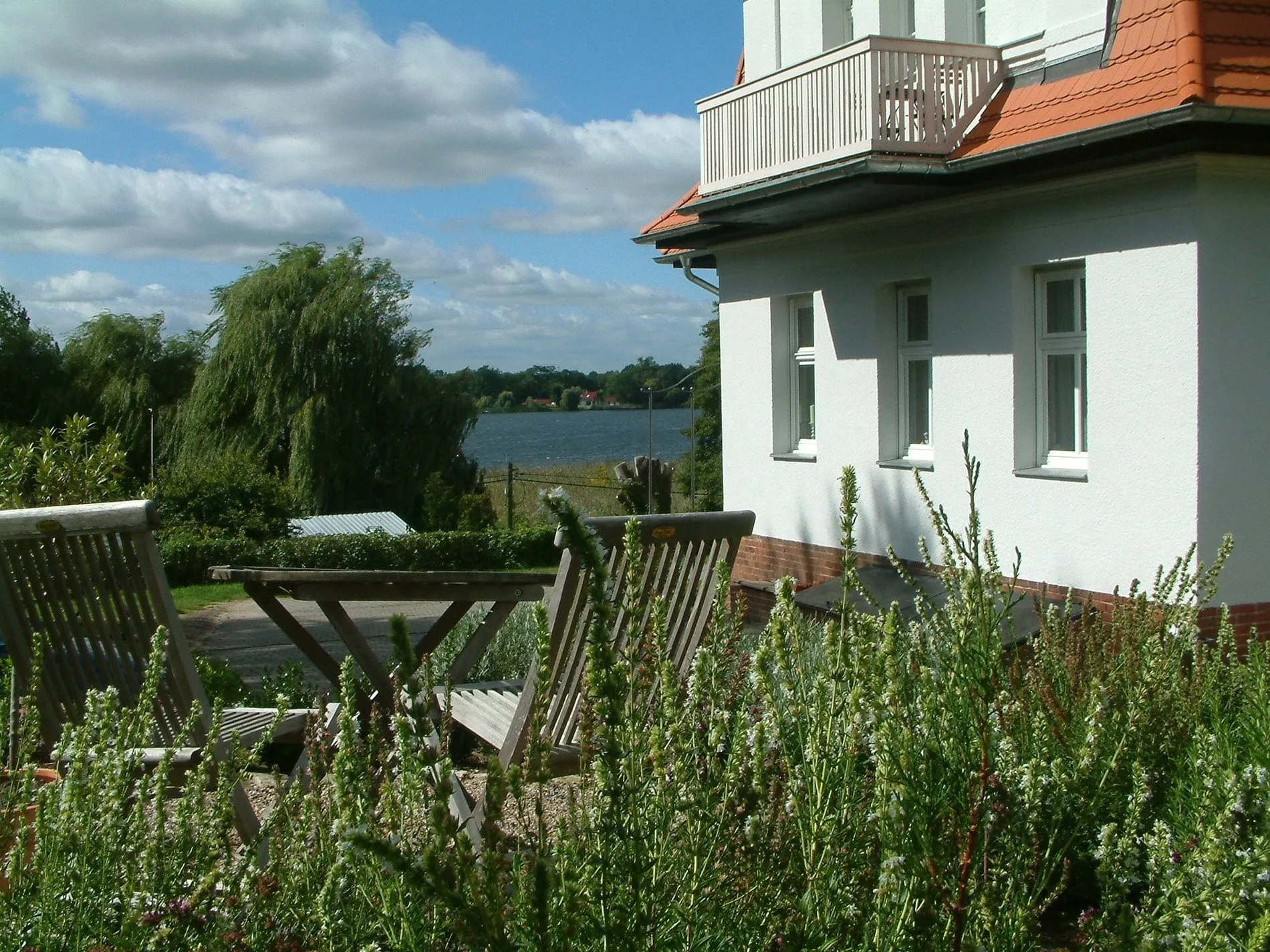 Balkon mit Stühlen und Tisch, dahinter der Schwielowsee