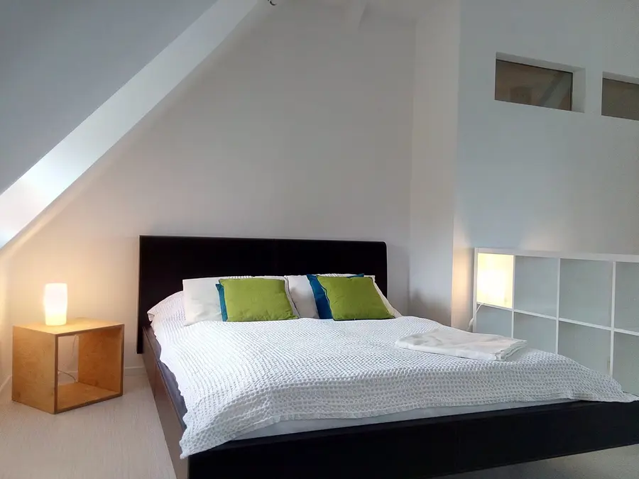 Schlafbereich im Dachstudio mit Doppelbett unter der Dachschräge