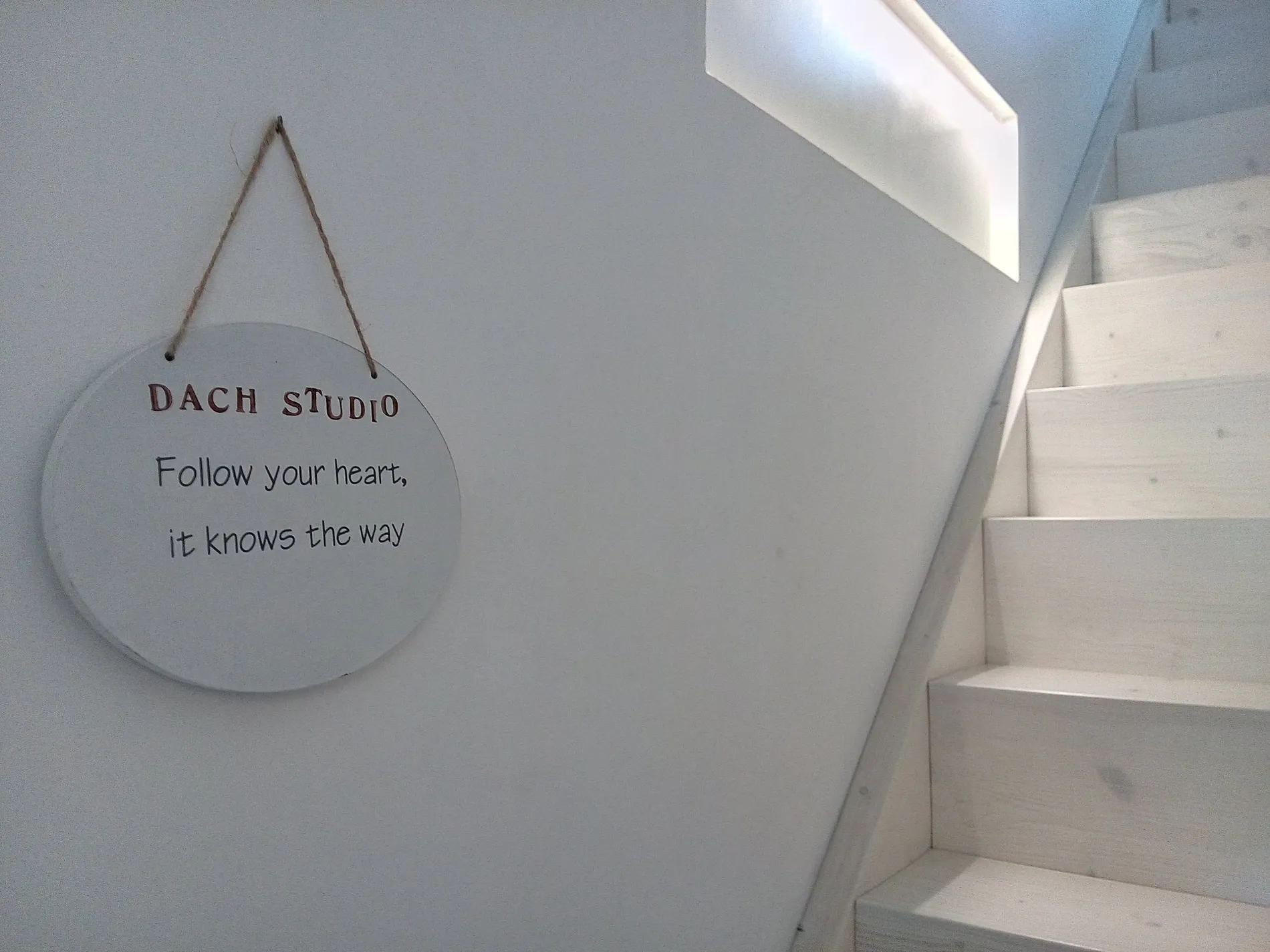 Ein Schild an der Treppe mit der Aufschrift Dach Studio