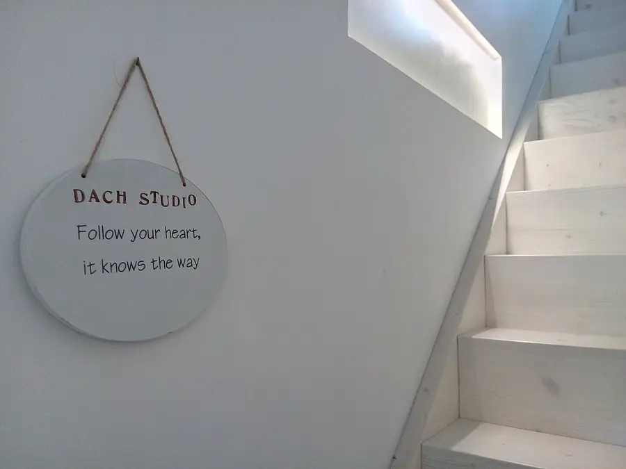 Ein Schild an der Treppe mit der Aufschrift Dach Studio